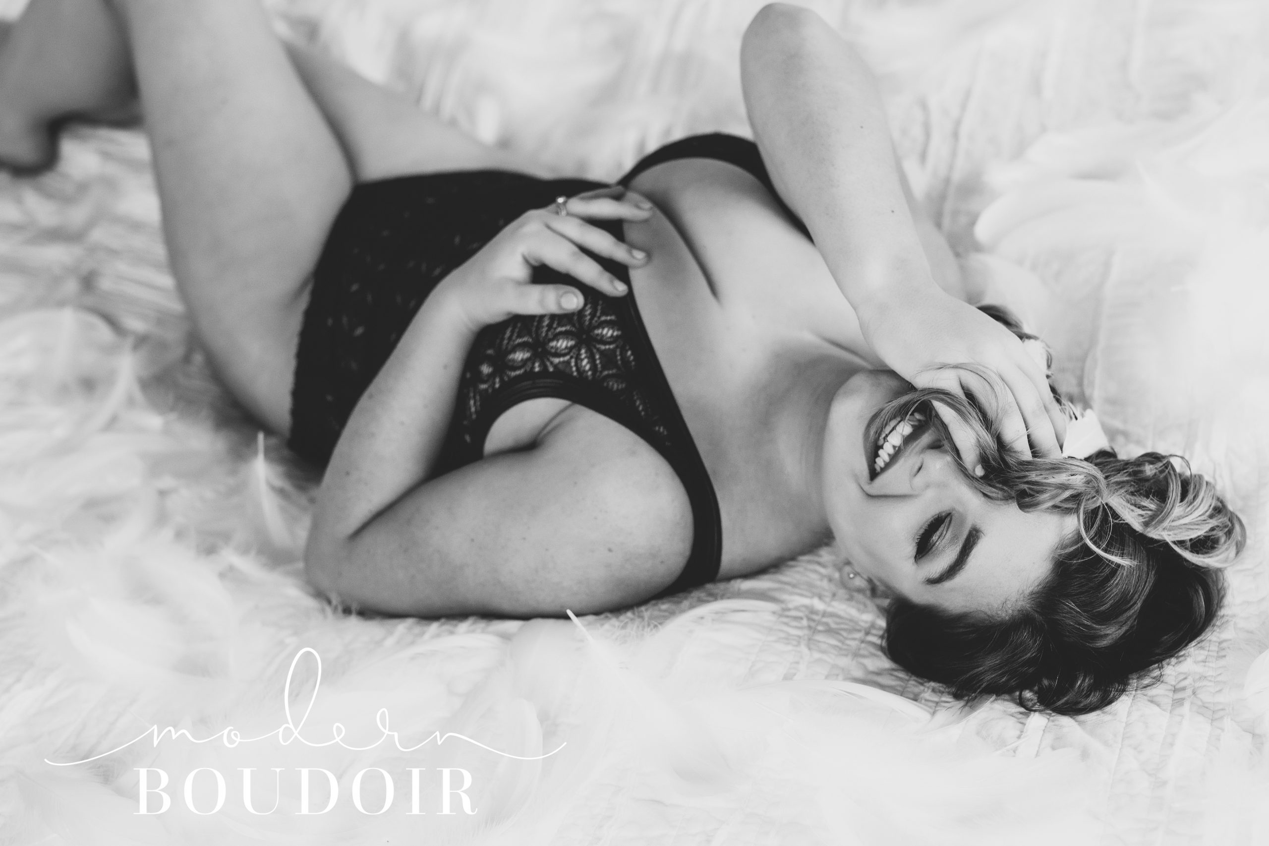 Woman laughing wearing bodysuit with feathers at Modern Boudoir